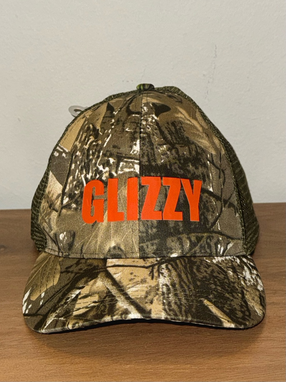 GLIZZY Camo Trucker Hat with Orange Logo